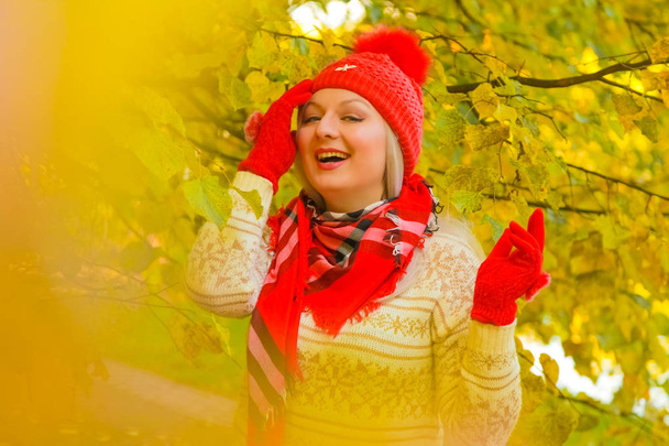 jeune jolie plus taille femme caucasienne en chapeau rouge avec pompon et gants tricotés promenades dans le parc d'automne
 - Photo, image