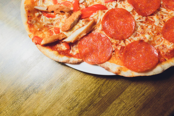 ピザチーズのスライスは、シーフードトッピングソースを粉砕。ピーマン野菜おいしいおいしいファーストフードイタリアの伝統的なソフトドリンク炭酸の木製ボードテーブルクラシックで新鮮な炭酸. - 写真・画像