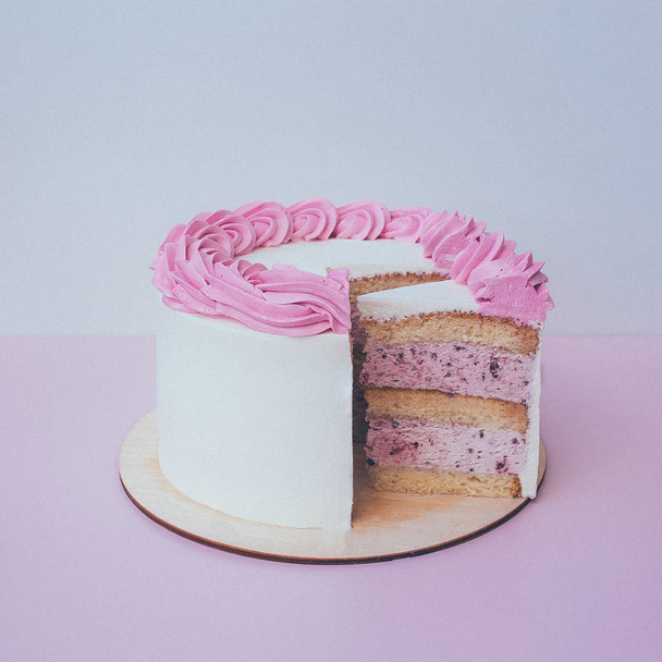 a cut of cake with whipped cream on the table background. - Foto, afbeelding