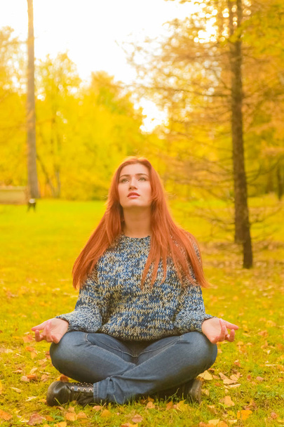 jovem bonita plus tamanho mulher caucasiana meditar no parque de outono
 - Foto, Imagem
