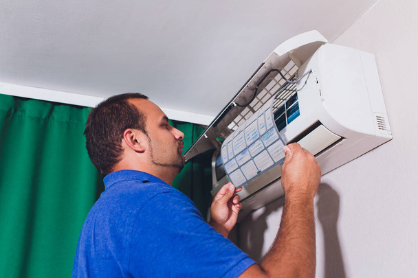 Male technician cleaning air conditioner indoors. service - Photo, Image