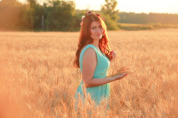 日没時に金色の熟した小麦畑を歩くドレスの女の子 - 写真・画像