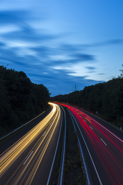 長時間露光の高速道路の巡航車のライト トレイル光高速道路の電気のパイロンの空の縞 - 写真・画像