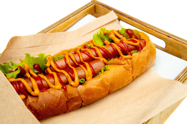 Hot dog with salad and cucumbers with tomato ketchup and mustard - 写真・画像