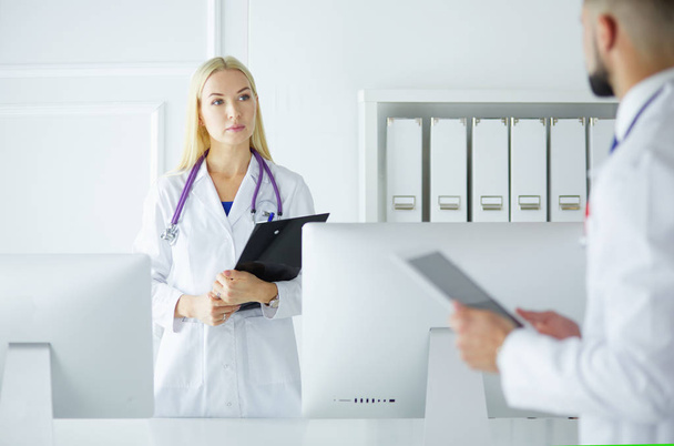 Woman doctor standing with folder at hospital - Zdjęcie, obraz