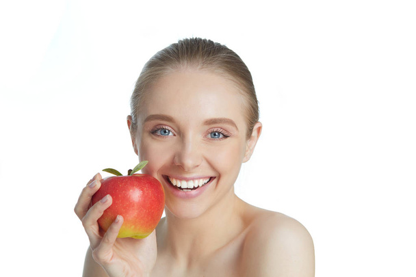 Portrait of happy smiling young beautiful woman eating red apple, over white background - Foto, Imagen
