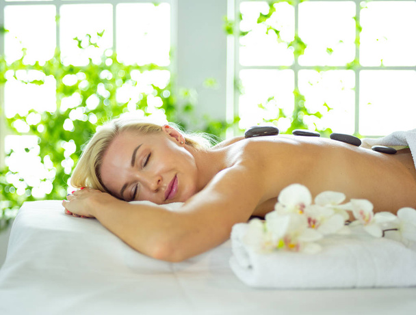 Young woman in spa salon, getting stones massage - Zdjęcie, obraz