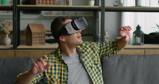 Young man has fun by wearing virtual reality headset - Video, Çekim