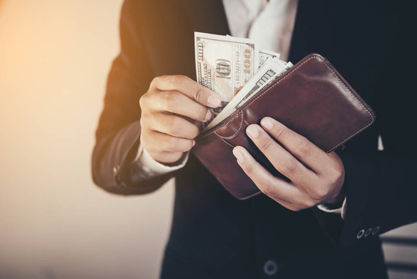 бізнесмен заощаджує гроші, людина несе гаманець в руці, лялька
 - Фото, зображення