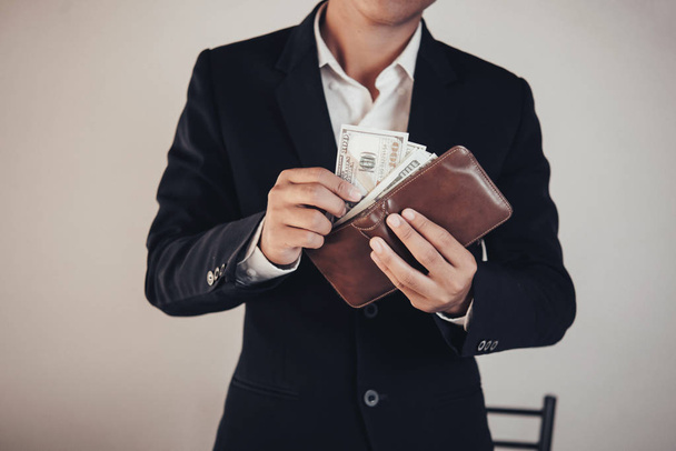 επιχειρηματίας εξοικονόμηση χρημάτων, ο άνθρωπος που κουβαλάει ένα πορτοφόλι στο χέρι, η κούκλα - Φωτογραφία, εικόνα