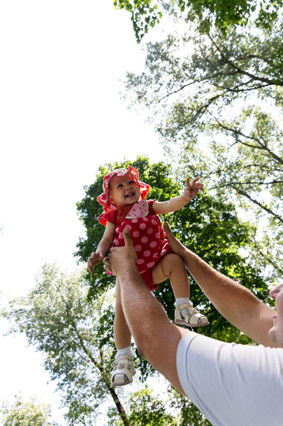 Father tossing up his daughter laughing - Фото, изображение