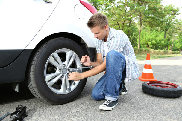 Man driver having trouble at road changing wheel - Photo, image