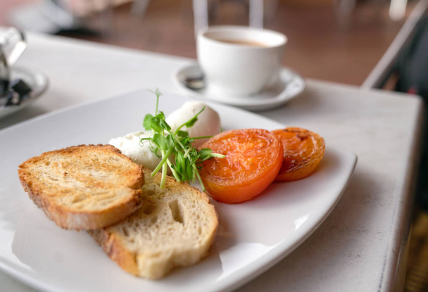 ポーチドエッグ、トマト、トーストパンのヘルシーな朝食 - 写真・画像