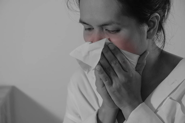 Porträt einer jungen Frau, die ins Gewebe niest. asiatische Frau hat - Foto, Bild