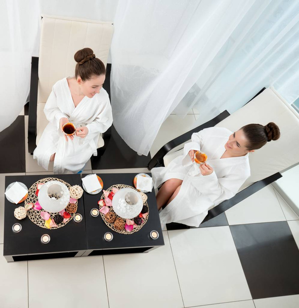 Top view of pretty girls drinking tea in spa salon - Photo, Image