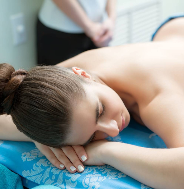 Spa massage. Young girl lying on her stomach - Valokuva, kuva