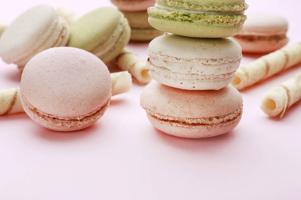 French macaroons and crispy wafer rolls on pink background.  - Photo, image