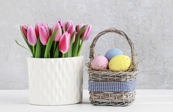 Bouquet of pink tulips and basket of Easter eggs - Φωτογραφία, εικόνα