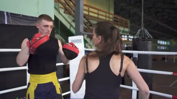 Kobieta szkolenia kłaniając z zawodowym bokserem człowieka. Ciosy w ręku - Materiał filmowy, wideo