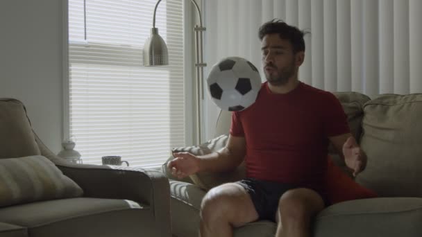 Slow motion of a man playing with soccer ball at home - Video, Çekim