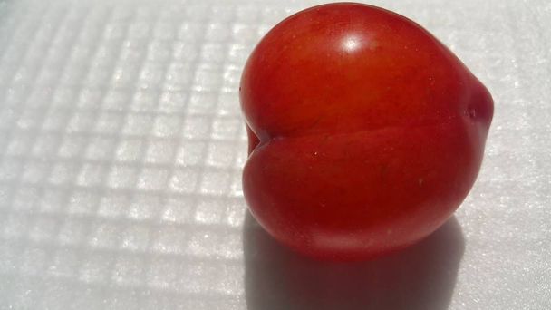 Vue rapprochée de prune rouge sur fond gris blanc
 - Photo, image