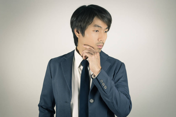 Jeune asiatique portrait homme d'affaires toucher menton Pose dans ton vintage
 - Photo, image