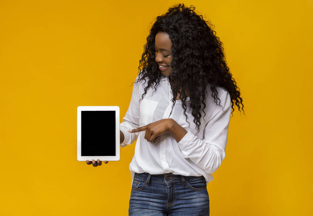 Black woman pointing at blank digital tablet screen - Fotó, kép