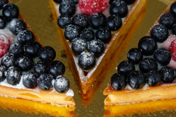 Pieces of berry tart on a gold plate  - Photo, Image