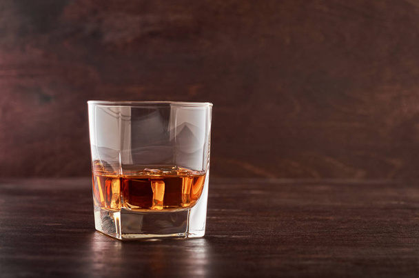 Glass of whiskey on a wooden table - Foto, imagen