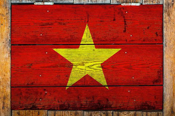 Nationale vlag van Vietnam op een houten muur achtergrond. Het concept van nationale trots en symbool van het land. Vlag geschilderd op een houten hek met metalen nagels. - Foto, afbeelding