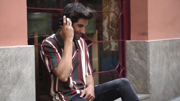 Fiatal férfi segítségével okos telefon ül a városi lépés. - Felvétel, videó
