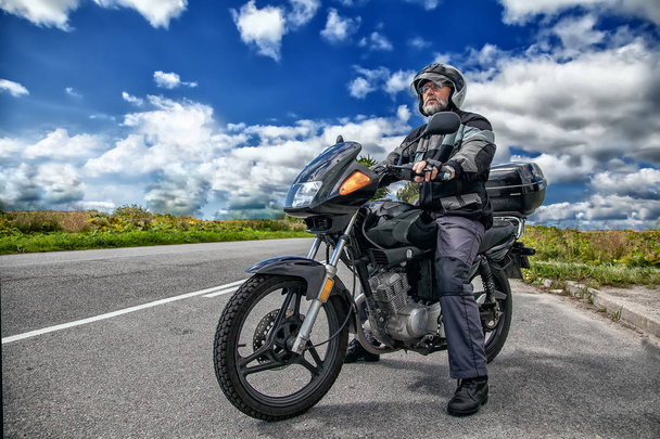 viejo motociclista sentado en su motocicleta en el camino abierto
 - Foto, imagen