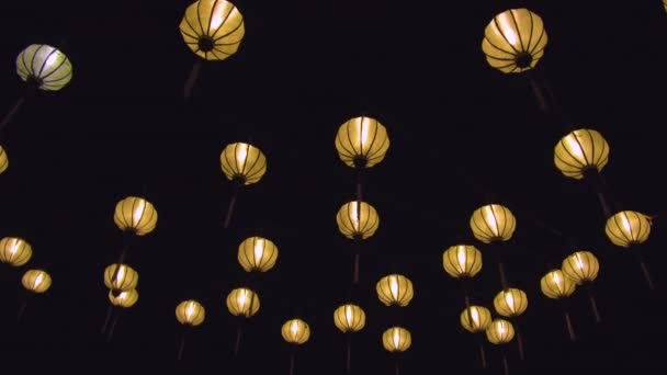 CLOSE UP: Beautiful decorative lanterns are lit up on a full moon celebration. Amazing paper lights glow bright in the dark night during an ancient Vietnamese celebration. Cool lamps illuminate street - Footage, Video