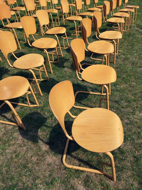 Gruppo di sedie gialle, in piedi fuori nel parco di fronte al palco
 - Foto, immagini