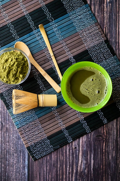 matcha of green tea in a bowl on a wooden surface. Top view, contains antioxidants, detox. Vertical orientation - Foto, immagini