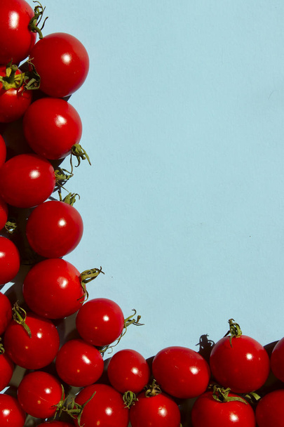 Tomates cerises rouges sur fond bleu. Fond alimentaire coloré. Publicité, concept d'ingrédients alimentaires
. - Photo, image