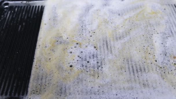 Las manos en la cocina lavan la parrilla, esponja con detergente de espuma de cerca
 - Metraje, vídeo