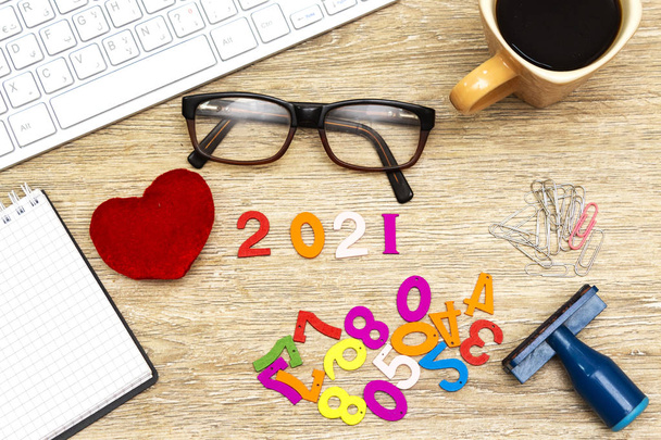 Flat lay foto de mesa de escritório com teclado, óculos e xícara de café, clipe de papel e caneta. ano novo 2021 conceito
 - Foto, Imagem