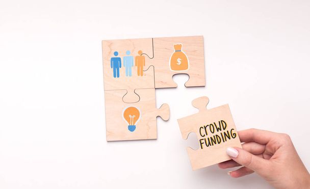 Puzzle de cuatro piezas que muestran el concepto de crowdfunding en blanco
 - Foto, Imagen