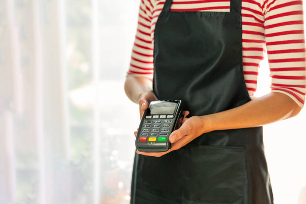 Winkelmedewerker die om betaling vraagt via NFC-technologie. Store w - Foto, afbeelding