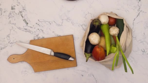 Stop motion animation of shopping bag with vegetables and cooking supplies on kitchen table  - Felvétel, videó