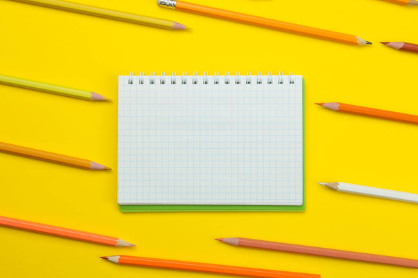 back to school. stationery colored pencils and notebook on a bright yellow background. top view - Valokuva, kuva
