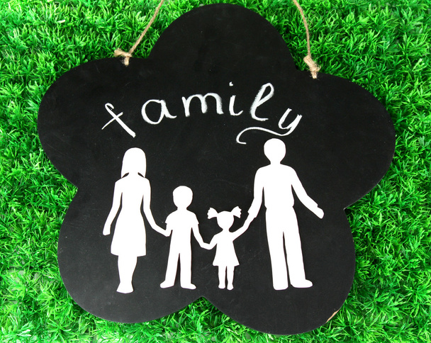 Family from paper on wooden board on bright background - Fotó, kép