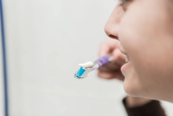 Giovane donna si lava i denti bianchi con uno spazzolino da denti
. - Foto, immagini