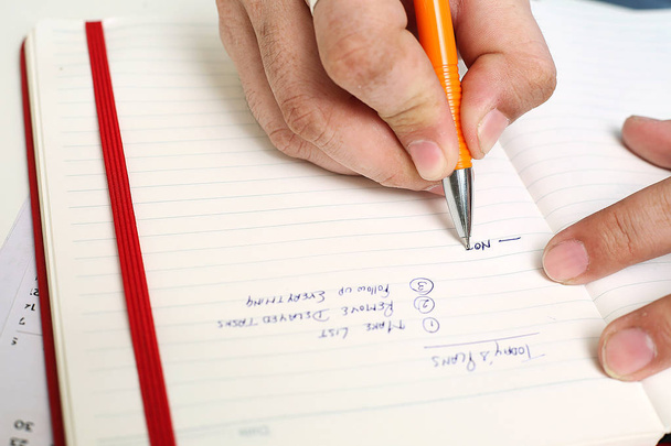 Foto de Hombre escribiendo en cuaderno con pluma. Aislado sobre fondo blanco
. - Foto, Imagen
