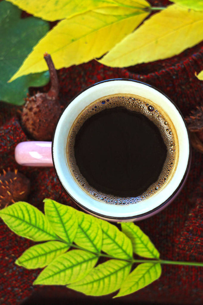Herfst koffie. Herfst bladeren met een kopje warme gezonde drank, warme wollen trui op een bruine houten achtergrond. Stilleven. - Foto, afbeelding