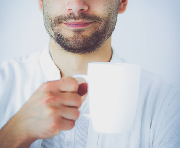 Young business man drinking a cup of coffee or tea - Фото, изображение