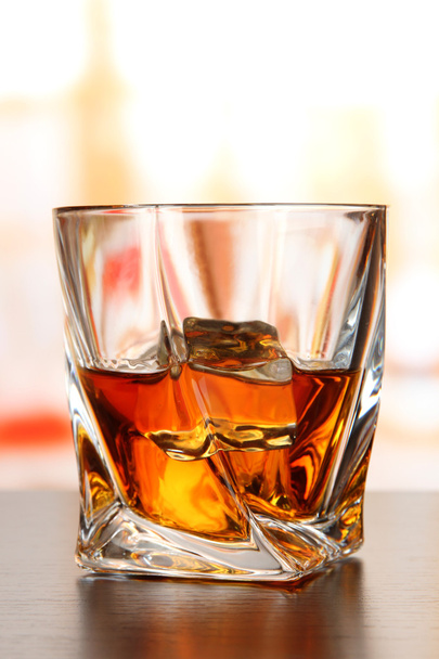 Glass of whiskey, on bright background - 写真・画像