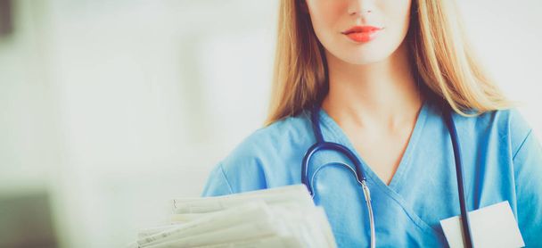 Portrait of woman doctor with folder at hospital corridor - Foto, imagen