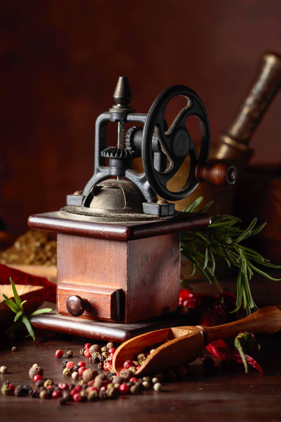 Macinapepe vintage con utensili da cucina, spezie e rosmarino
 - Foto, immagini